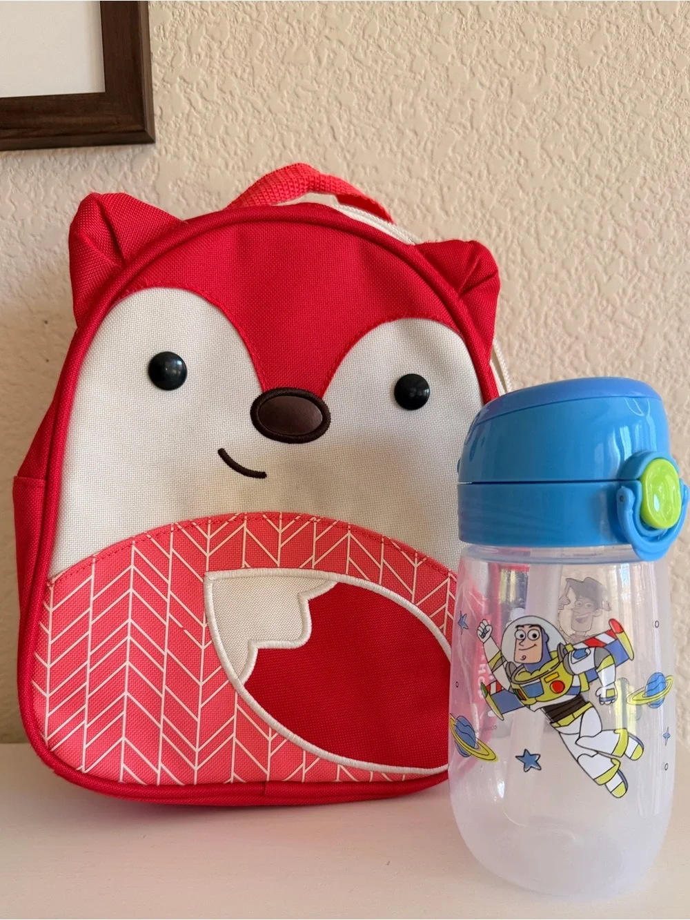 Skip Hop Zoo Mini Backpack with Blue and Toy Story Sippy Cup.